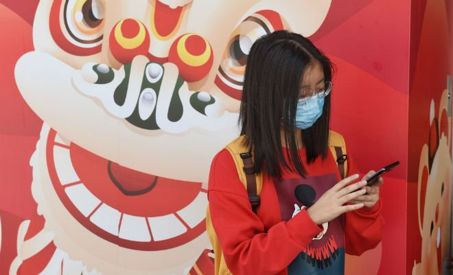 Pedestre cobre o rosto com máscara sanitárias após a confirmação dos primeiros casos de coronavírus em Hong Kong, China. Foto de 23 de janeiro de 2018. — Foto: Miguel Candela Poblacion/Anadolu Agency 
