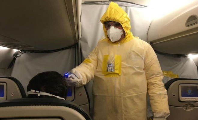 Militar da equipe médica do Instituto de Medicina Aeroespacial (IMAE) afere a temperatura de um dos brasileiros a bordo do VC-2 da FAB em Wuhan, na China — Foto: Força Aérea Brasileira/Divulgação 