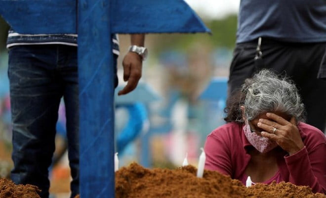 Cemitério Parque Taruma, Manaus: mulher acompanha enterro em massa de pessoas que morreram de covid-19 | Imagem: Bruno Kelly/Reuters
