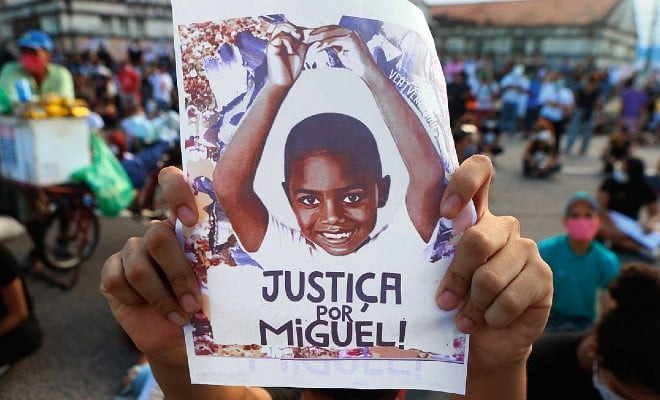 O pai de Miguel, Paulo Inocêncio, segura uma foto do filho em manifestação que pede justiça por sua morte. Foto: Guga Matos / JC Imagem / Folhapress 