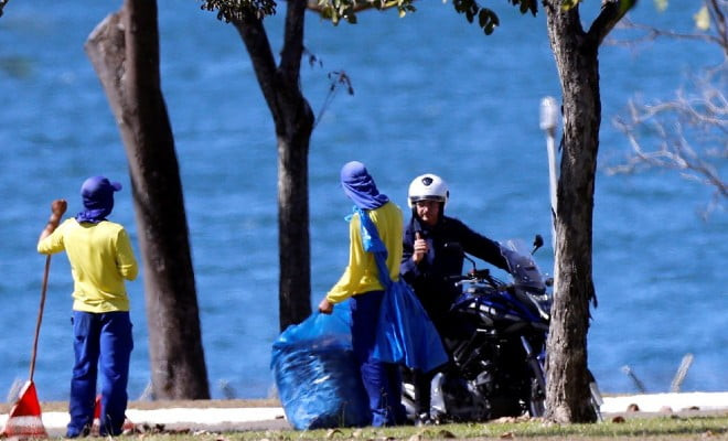 Sem máscara, o presidente Jair Bolsonaro conversa com funcionários do Palácio da Alvorada, em Brasília, após tirar o capacete durante passeio de moto dentro da área do palácio. — Foto: Foto: Adriano Machado/Reuters 
