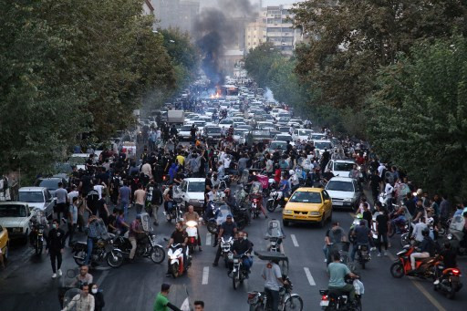 A picture obtained by AFP outside Iran on September 21, 2022, shows Iranian demonstrators taking to the streets of the capital Tehran during a protest for Mahsa Amini, days after she died in police custody. - Protests spread to 15 cities across Iran overn