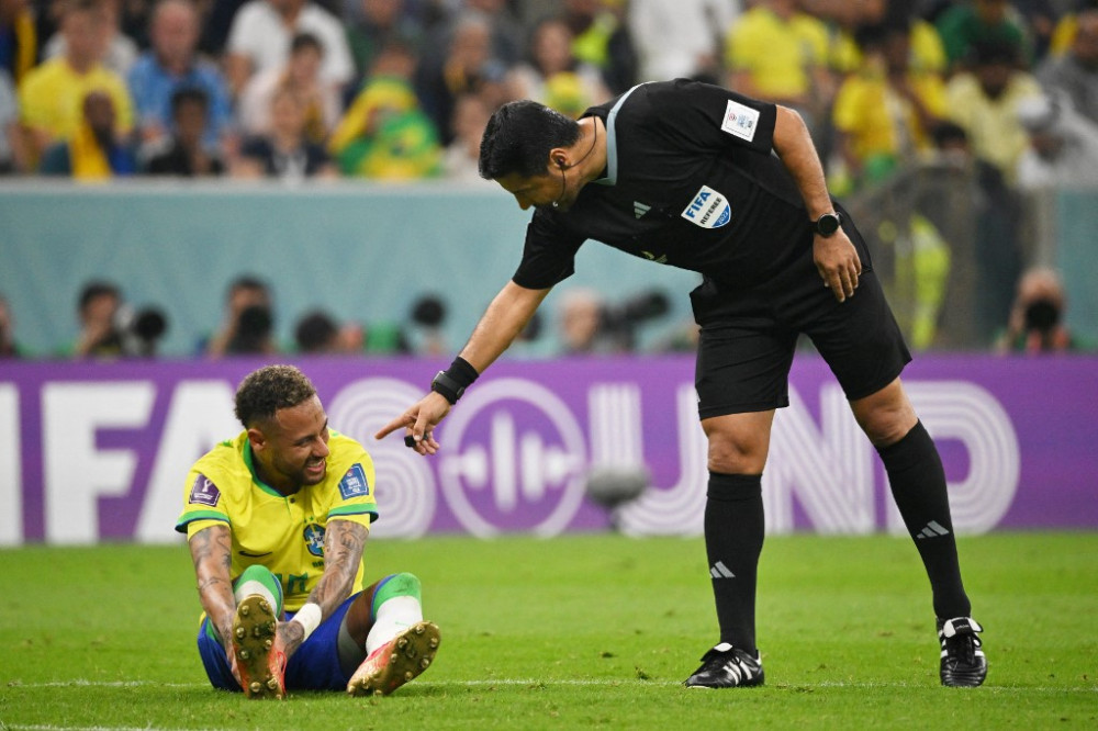 Iranian referee Alireza Faghani (R) gestures to Brazil's forward #10 Neymar during the Qatar 2022 World Cup Group G football match between Brazil and Serbia at the Lusail Stadium in Lusail, north of Doha on November 24, 2022. (Photo by NELSON ALMEIDA / AF
